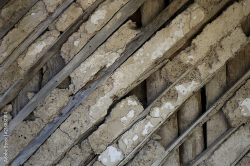Old wall of wattle and daub house with wooden diagonal stripes. Vintage texture background. Rustic view.