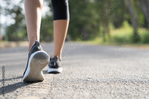 Runner feet running on road closeup on shoe. Woman fitness sunrise jog workout welness concept. Young fitness woman runner athlete running at road