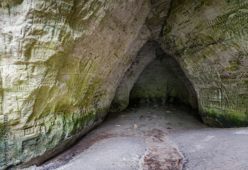Natural cave in sandstone rock. Entrance to the cave called Little Hell in the Gauja National Park, Latvia. Close-up. Soft focus.