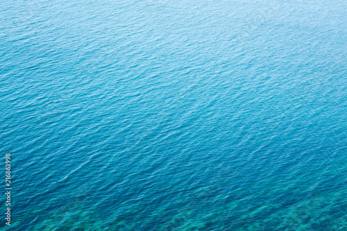 The texture of the water. Clear blue sea water with a stone slab on the bottom.