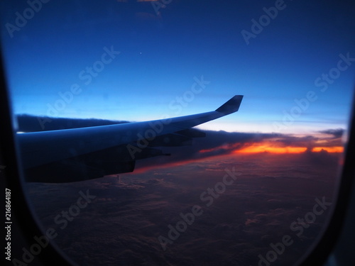 View from an airplane window to see the sky in the evening time at sunset in beautiful colors.