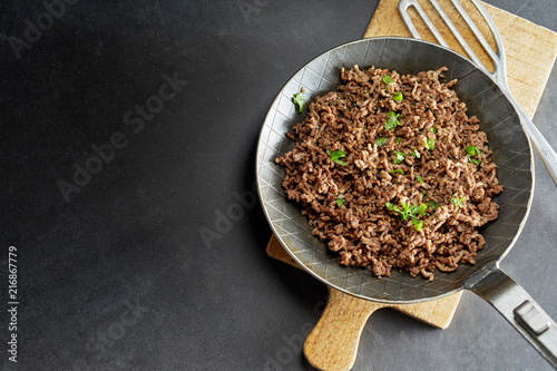 Fotografie Minced meat fried on pan with green chives