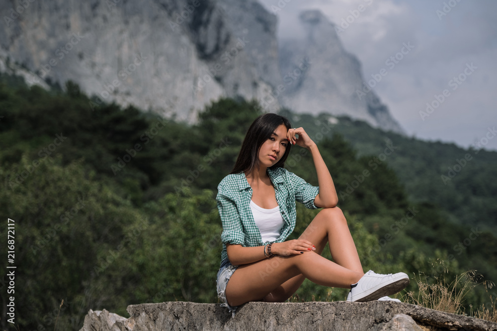 Beautiful young woman travels through a mountainous area.