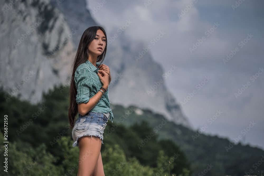 Beautiful young woman travels through a mountainous area.