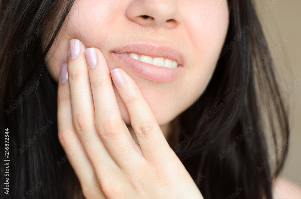 A girl touches her face because of toothache A girl touches her face because of toothache