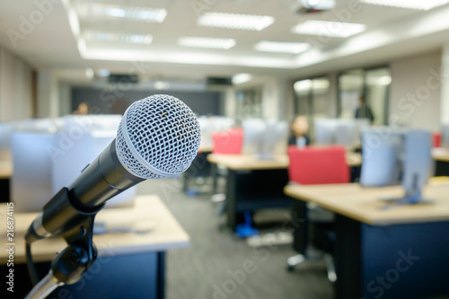 Microphone wire in stand with blurred background of people in computer classroom