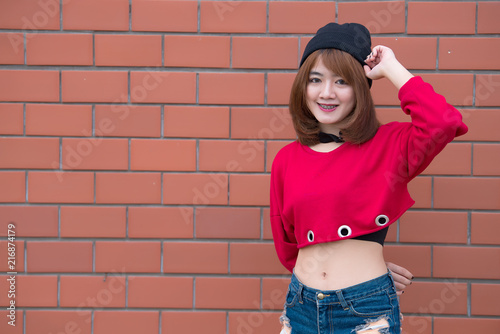 Portrait of beautiful asian chic girl wear black dress pose for take a picture on brick wall,Lifestyle of teen thailand people,Modern woman happy concept