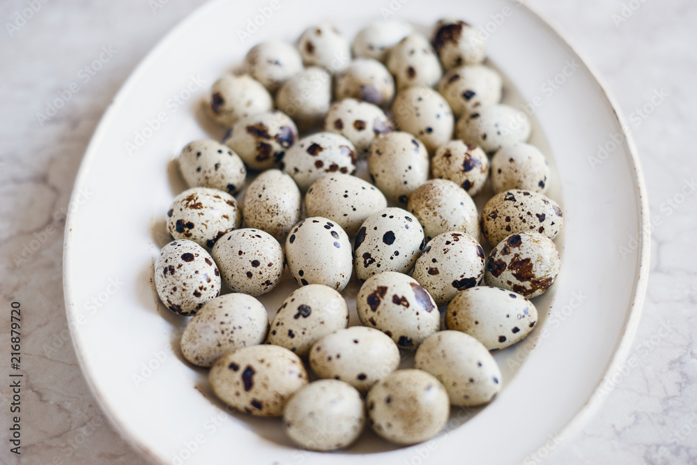 Raw healthy organic quail eggs in plate 