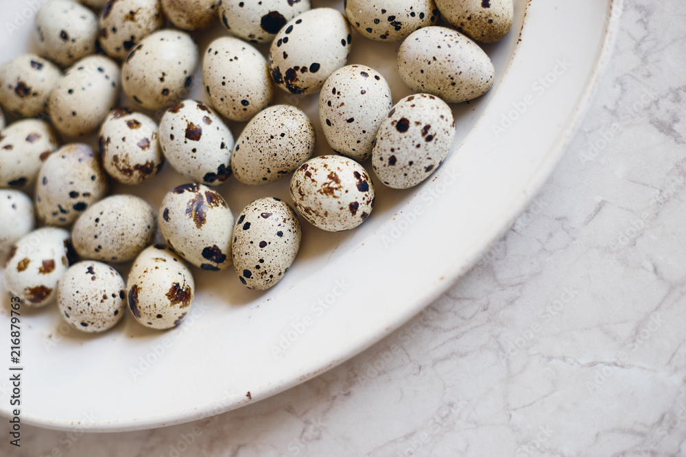 Healthy organic raw white quail eggs in white plate 