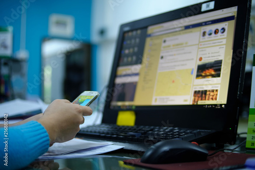 Woman relax with mobile phone and computer afber working photo