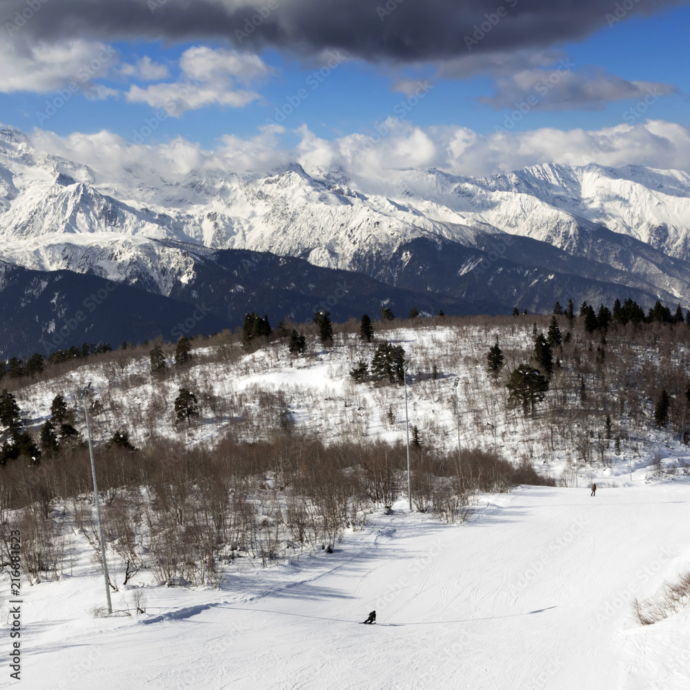 Skiers on ski slope at sun winter day