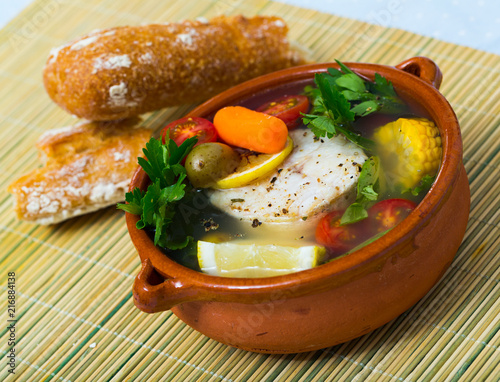 Fisherman's soup cooked with boiled pollock, carrots, corn and greens photo