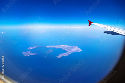 Aerial view from Santorini Island from a plane with window and airplane wing, Santorini, Greece