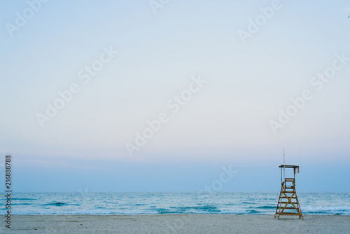 Lifeguard watchtower on the beach at sunset.