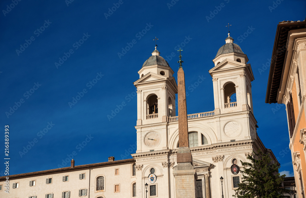 Twin bell towers of Trinità dei Monti renaissance church with ancient egyptian obelisk, at the top of famous Spanish Steps, in the center of Rome (with copy space on the left)