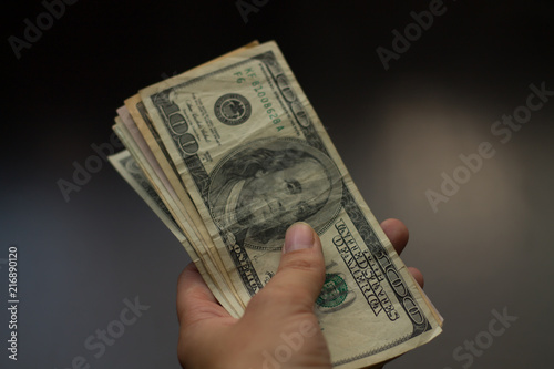  a human hand donates 100 dollars of banknotes, cash for the purchase of goods