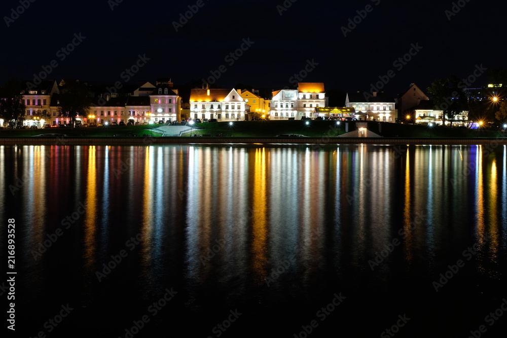 Troickoe predmeste is a picturesque old quarter on the bank of the Svisloch River in the center of Minsk. The night city is reflected in the river.