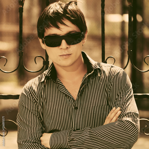 Young handsome man in sunglasses and striped shirt photo