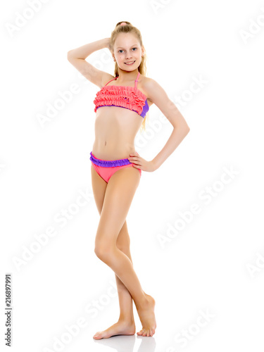 A little girl in a bathing suit in full growth.