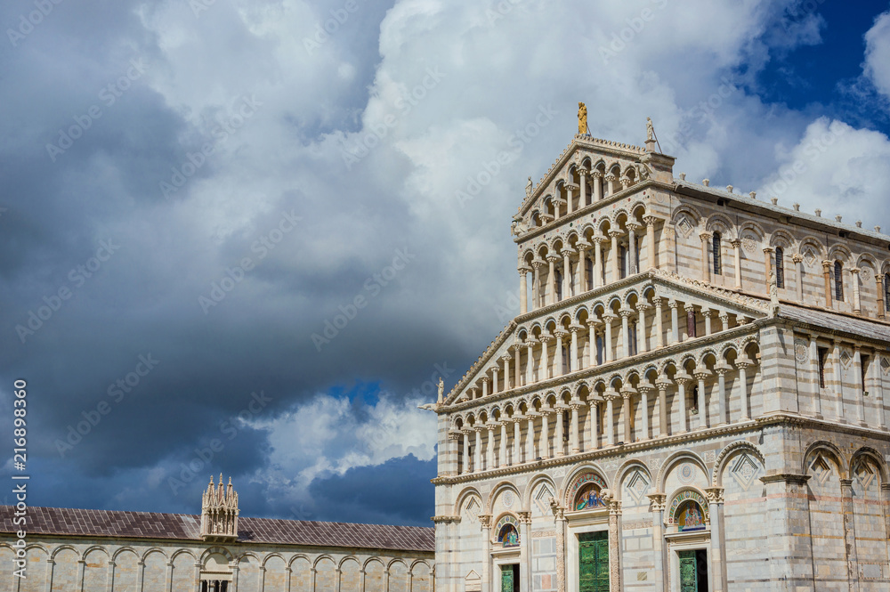 Pisa Cathedral romanesque facade, completed in the 12th century, with clouds and copy space