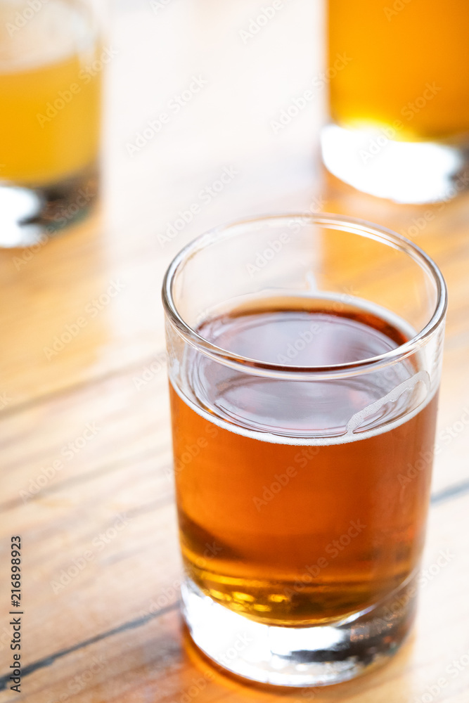 Close up on a glass of amber ale on a wood table, with space for text on top Close up on a glass of amber ale on a wood table, with space for text on top