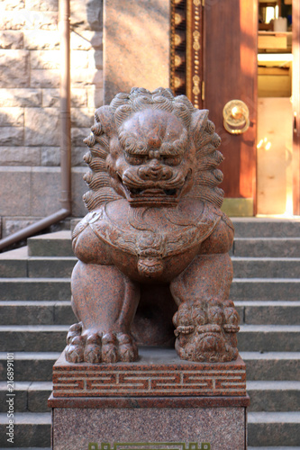 Sculpture of the Far Eastern lion from granite. Buddhist traditional sangha of Russia. Datsan Gunzehoyney. photo