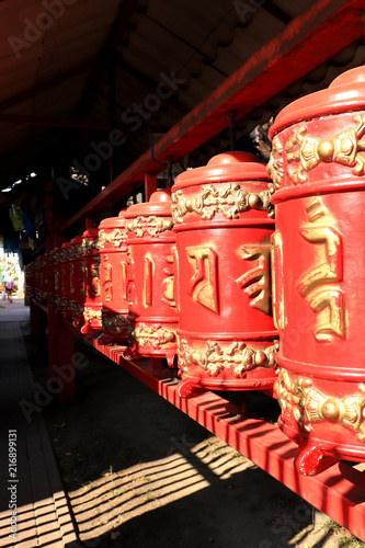 Red prayer drums row pathway. Buddhist traditional sangha of Russia. Datsan Gunzehoyney. Buddhist temple. Saint-Petersburg. photo