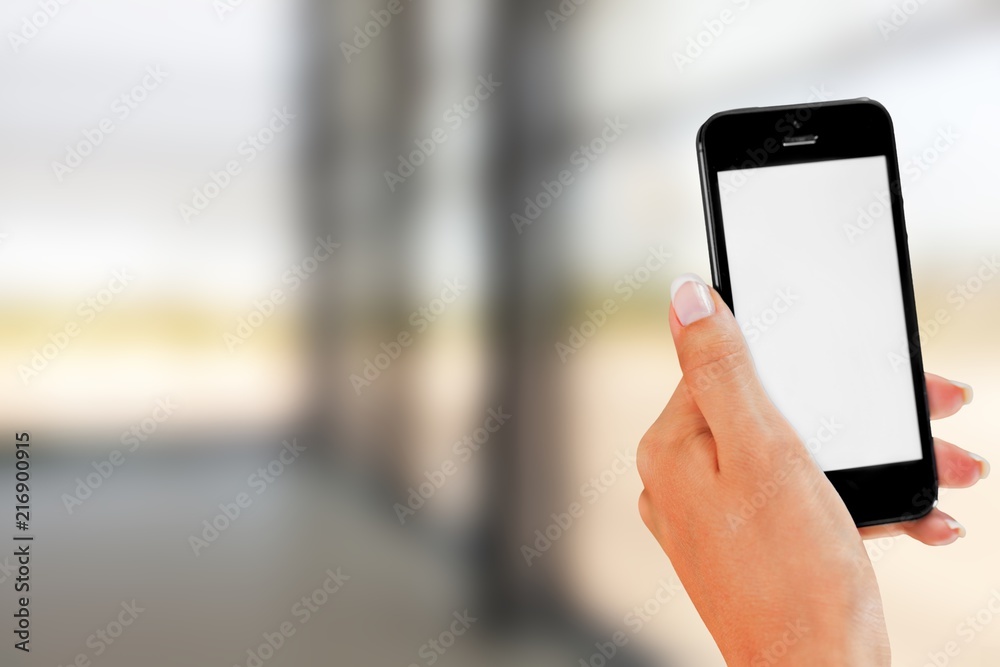 Hand holding smartphone on blurred background Hand holding smartphone on blurred background