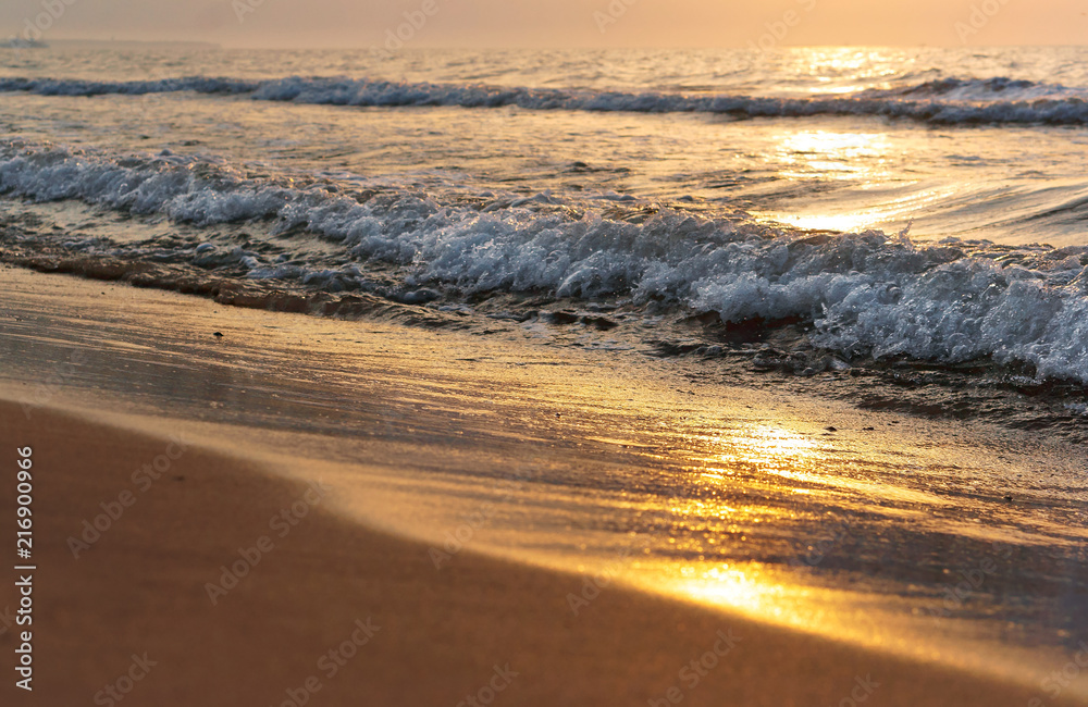 Obraz premium Sunset over the sea. Reflection of sunlight in the sea waves. Red sky in the rays of the sunset.