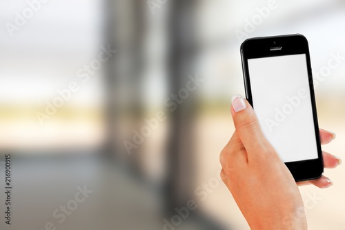 Hand holding smartphone on blurred background