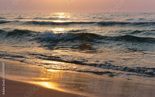 Sunset over the sea. Reflection of sunlight in the sea waves. Red sky in the rays of the sunset.