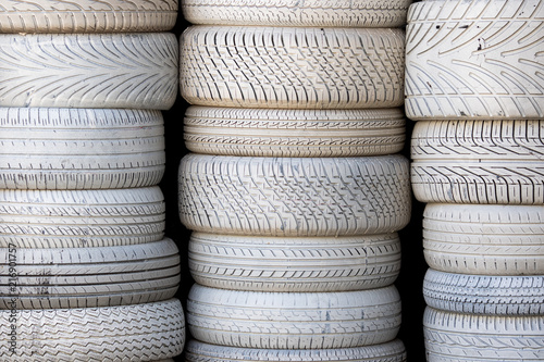 White tires. Stack of car tyres painted white. Automobile background image.