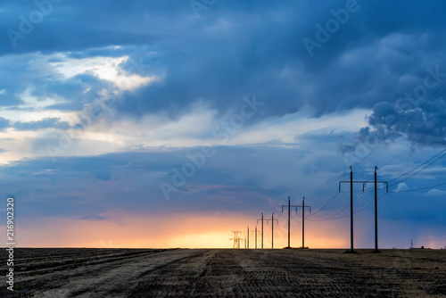 Rural landscape with power poles at sunrise