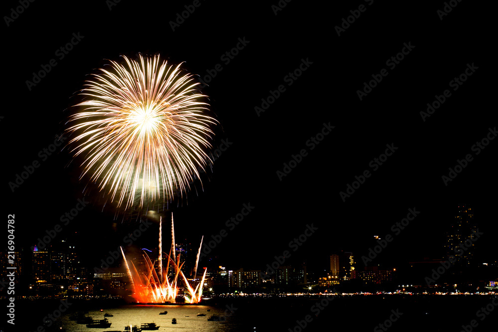 Many flashing fireworks with night cityscape background celebrate New Year.