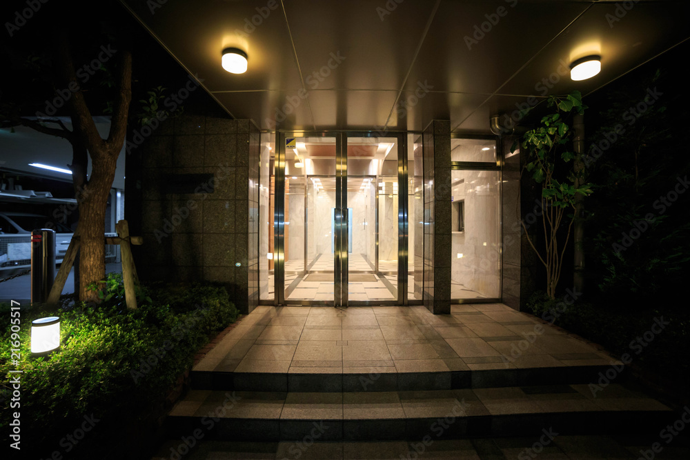 Sliding glass doors at entryway to apartment building at night