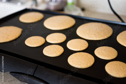Cooking wheat pancakes for american breakfast on black griddle