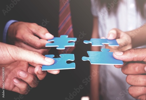 Business people holding puzzle pieces