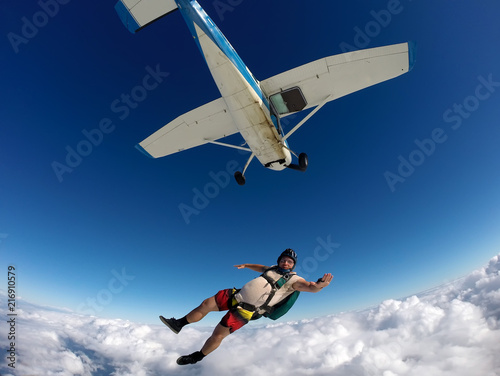 Parachutist in casual clothes jumping off the plane on a summer day