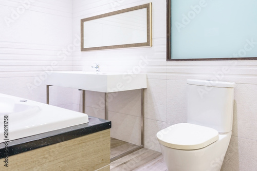 Modern spacious bathroom with bright tiles with toilet and sink.