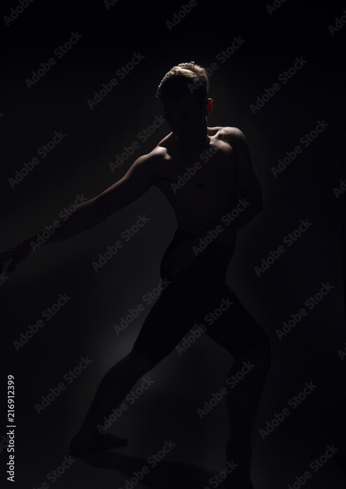 one ballet dancer, dark black background, backlit backlighting.