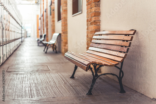 Side and low angle view photo from a wood bench in a quiet hall. This picture is about  calm e relax hall 