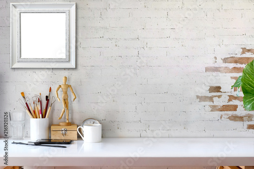 Mock up poster frame and artist craft tools in hipster room, scandinavian style interior with copy space