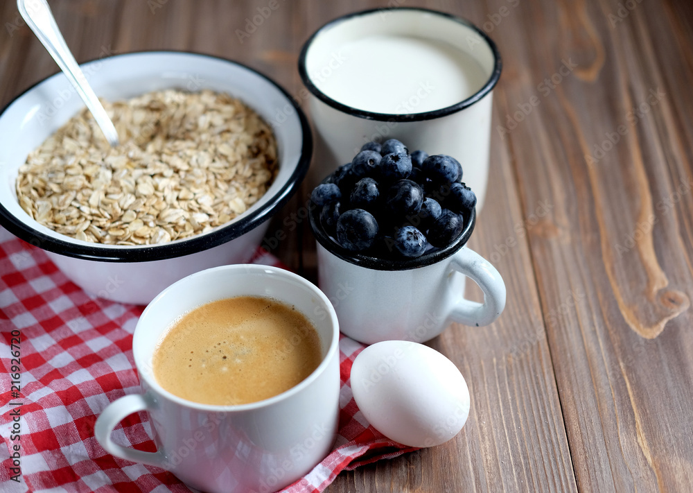 A healthy breakfast - Oatmeal porridge, boiled egg, milk, fresh berries and coffee. A great start to a new day. A healthy breakfast - Oatmeal porridge, boiled egg, milk, fresh berries and coffee. A great start to a new day.