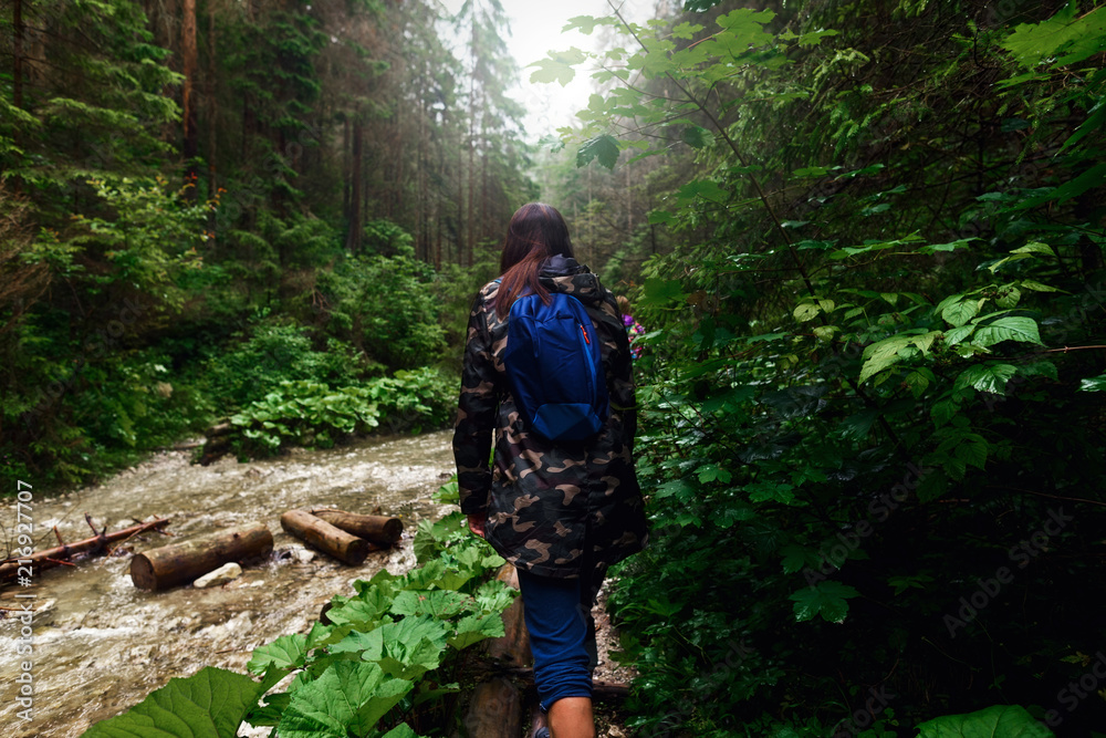 Woman backpack walking dense forest along river Travel backpacking lifestyle Woman backpack walking dense forest along river Travel backpacking lifestyle