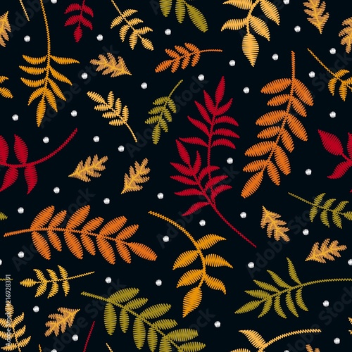 Embroidery seamless pattern with autumn leaves in different colors and first snowflakes. Colorful embroidered plants in fall season isolated on black background. Vector print.