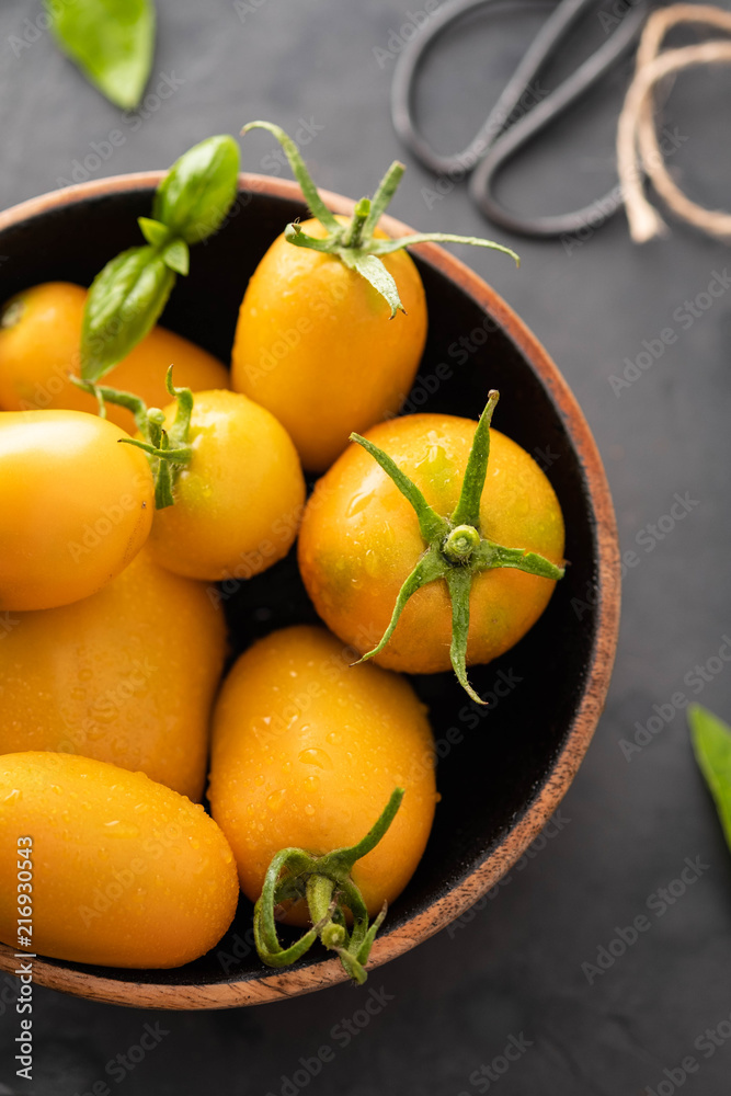Yellow Tomatoes as high detailed close-up shot on wooden table selective focus.