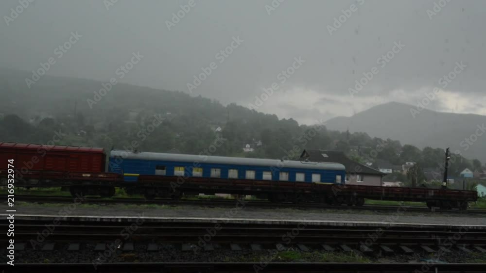 Old train stands on a countryside railroad station under havy rain. Nobody is on a station Old train stands on a countryside railroad station under havy rain. Nobody is on a station