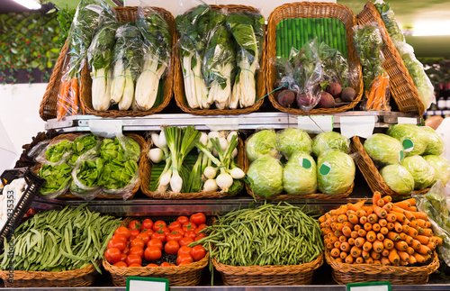 Fototapeta Naklejka Na Ścianę i Meble -  vegetables and fruits in wicker baskets on counter of greengrocery