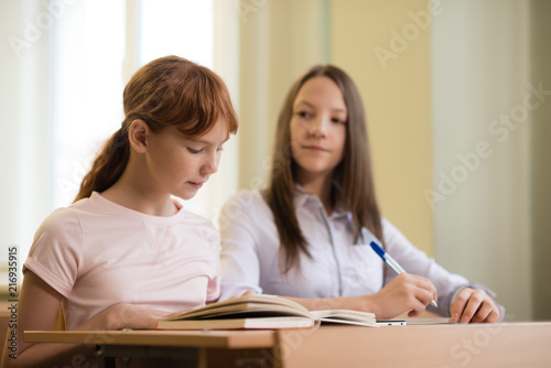 2 student girls are sitting at a Desk © Evgeny Sumin
