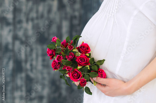 belly of pregnant woman with flowers